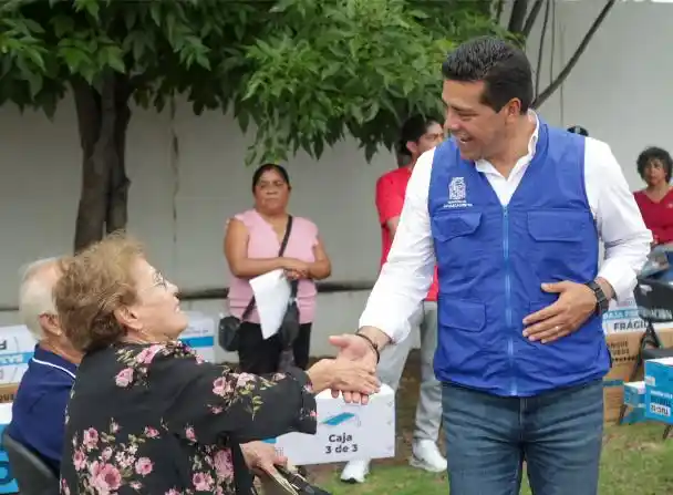 El presidente municipal Leo Montañez estrecha la mano de una beneficiaria durante la entrega de equipamiento para el hogar. A través de la estrategia La Ciudad de tu Vida, las familias acceden a apoyos como calentadores solares con esquemas de subsidio.